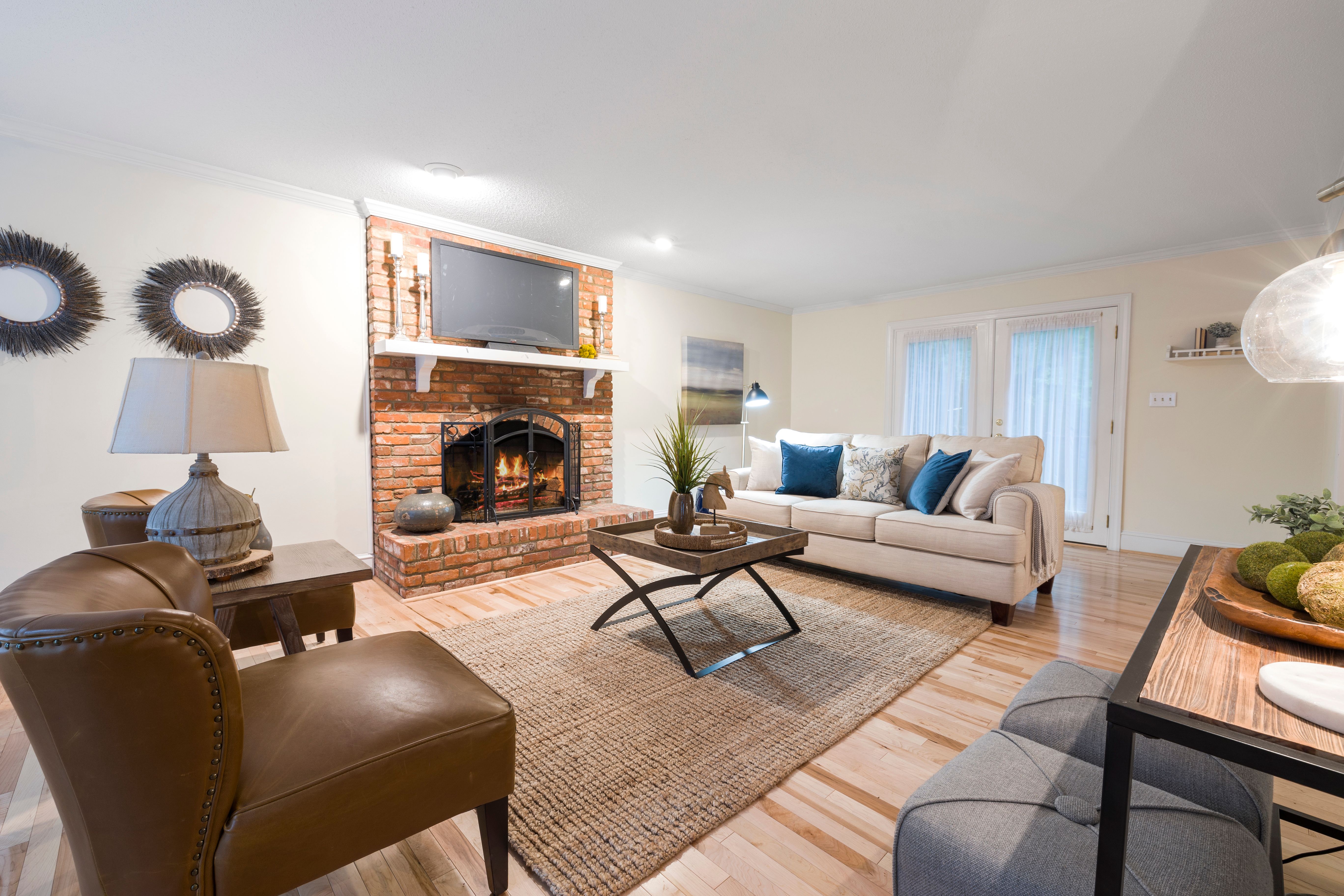 Warm living room with brick fireplace and leather armchairs
