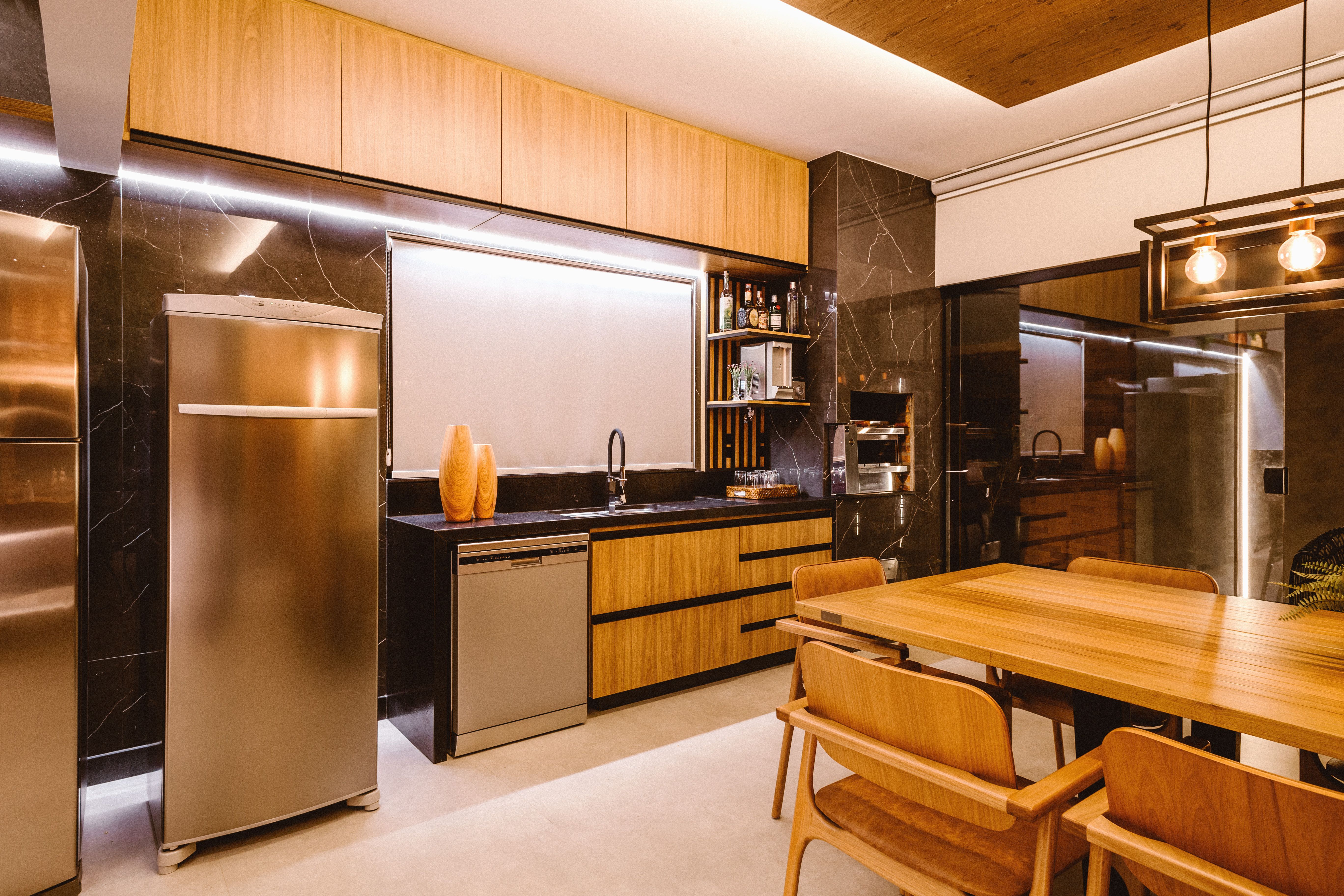 Spacious dining area integrated with warm wooden ceiling and statement pendant lights