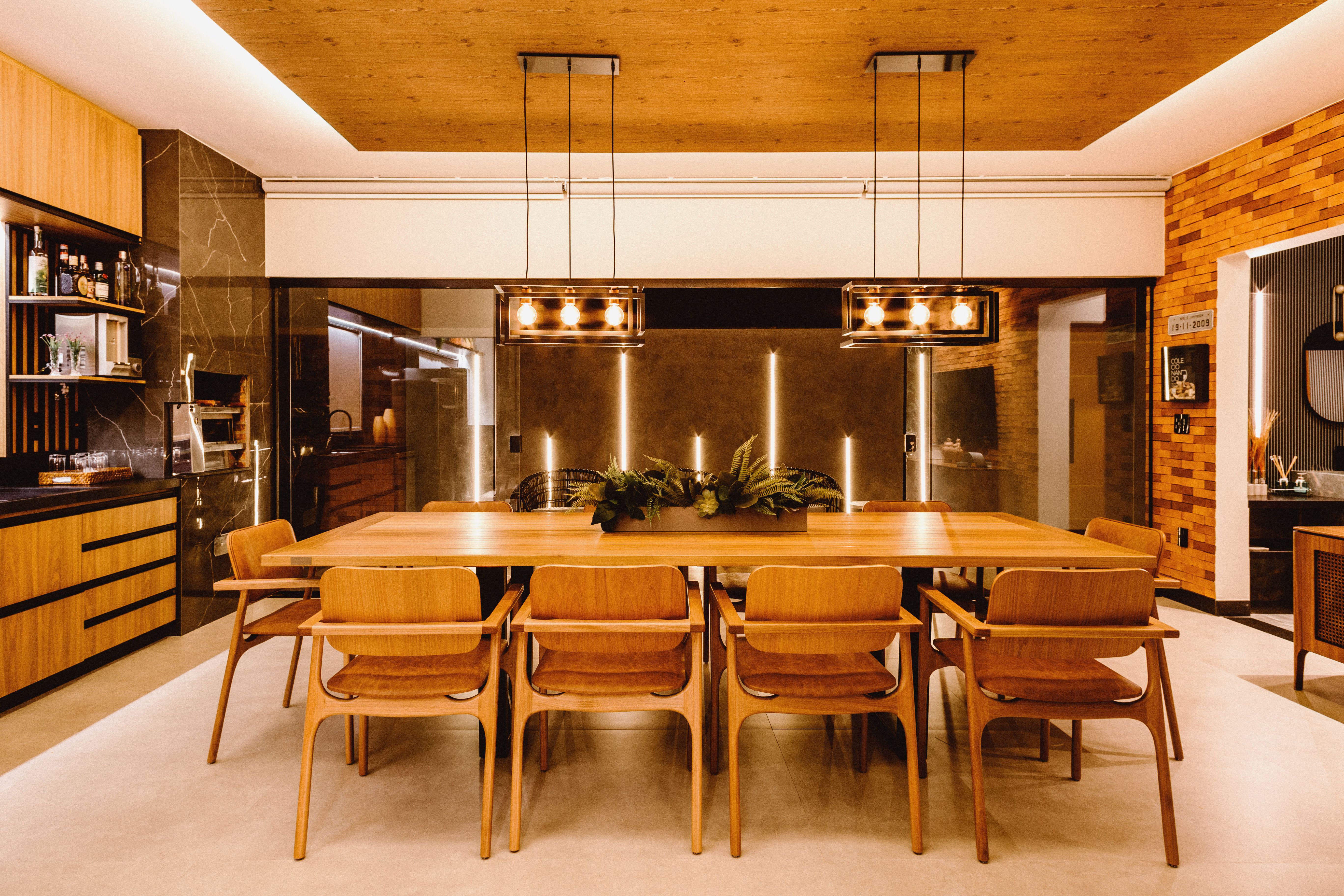 Modern kitchen with warm wood cabinetry, stainless steel refrigerator, and dark marble walls