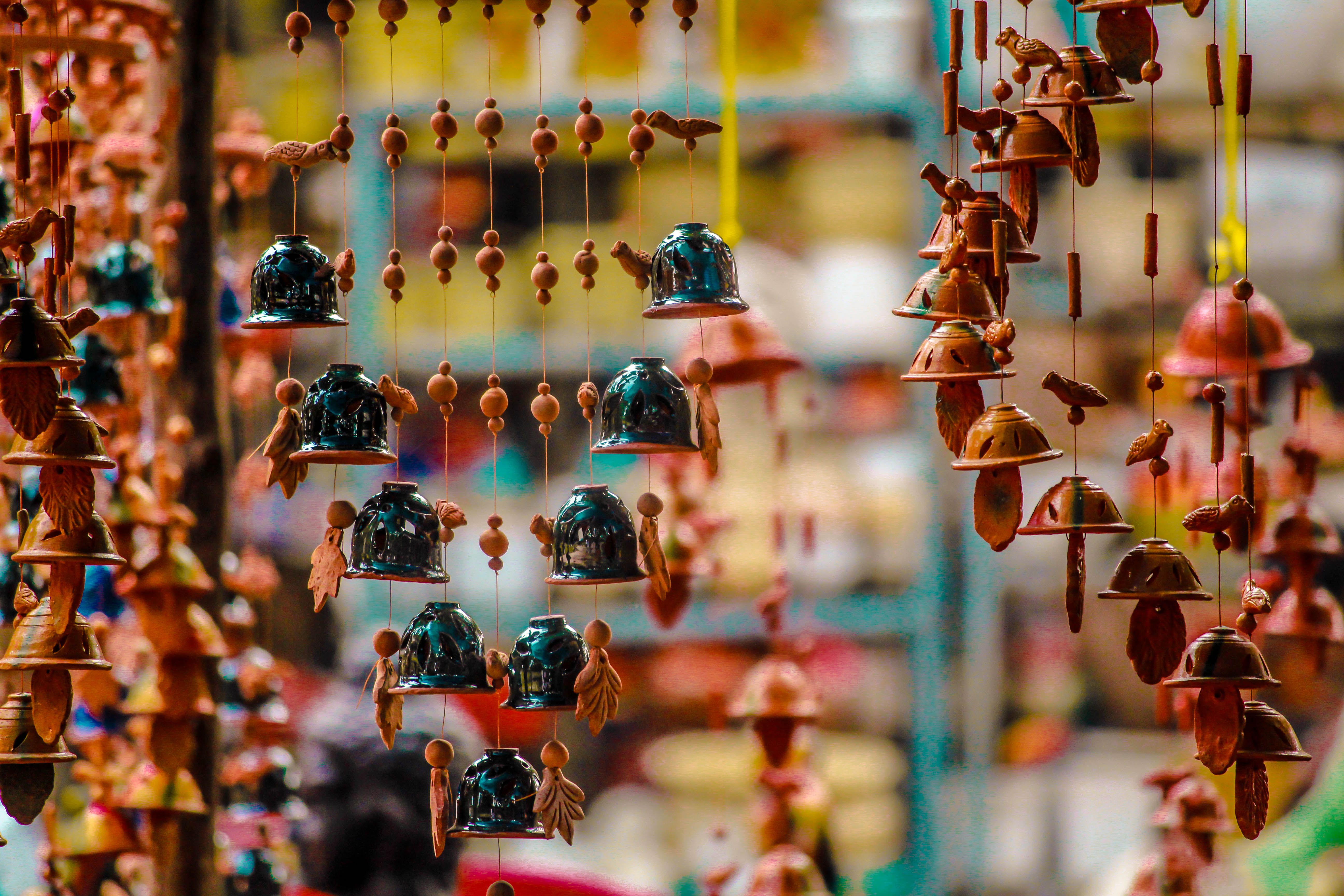 Colorful handmade ceramic wind chimes hanging at an artisan market