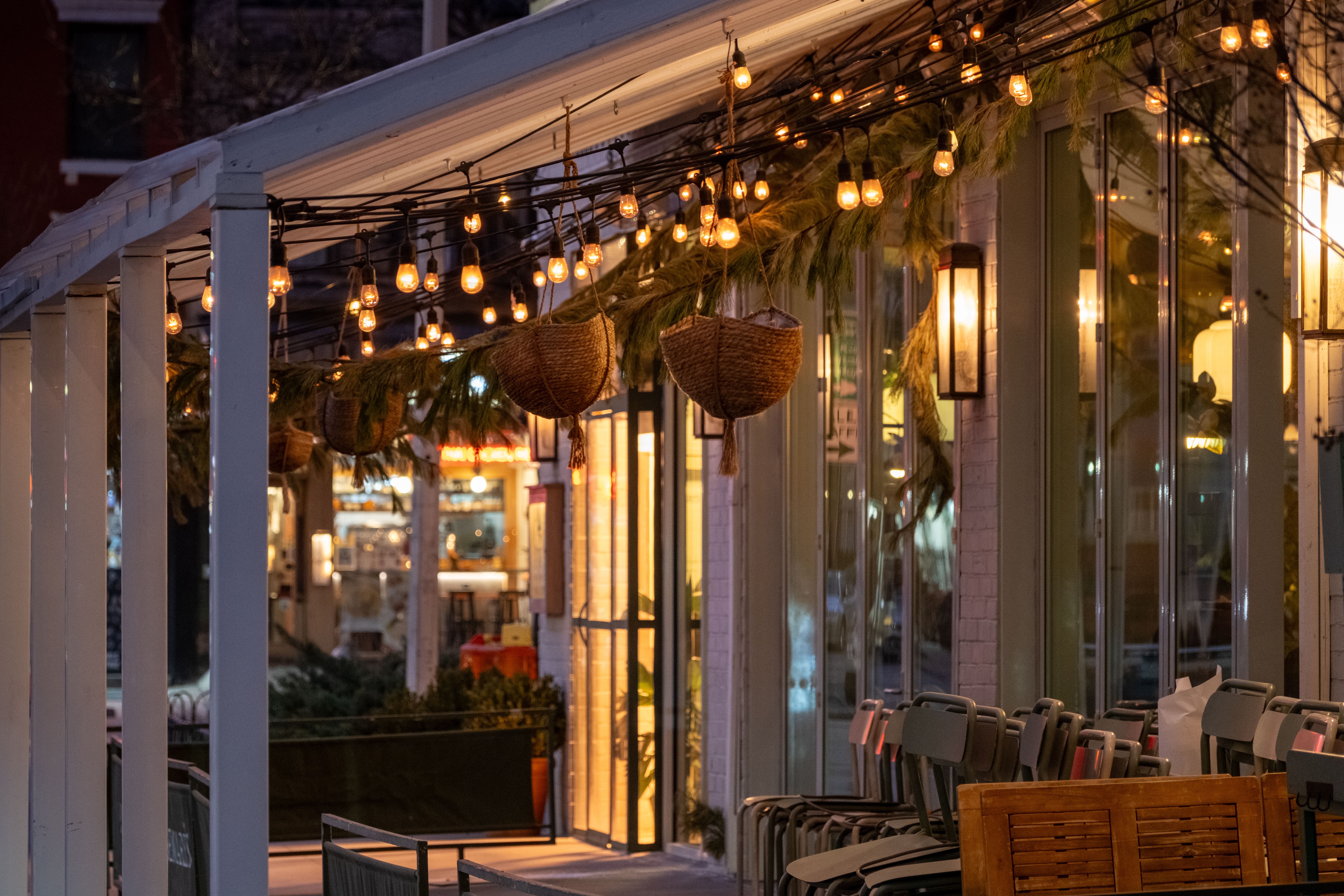 Warm string lights and glass lanterns illuminating a cozy apartment balcony at night